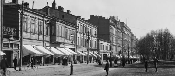 Pohjoinen Esplanaadikatu (Pohjoisesplanadi) 41, 39, 37, 35. Kaksi- tai kolmekerroksisia puurakennuksia, jalankulkijoita ja pyöräilijöitä, kaasulyhty.