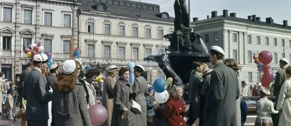 Vuxna och barn har samlats kring Havis Amanda. En del har en ballong i handen.