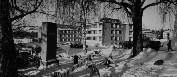 Suorakulmainen kivipaasi lumisessa maisemassa.