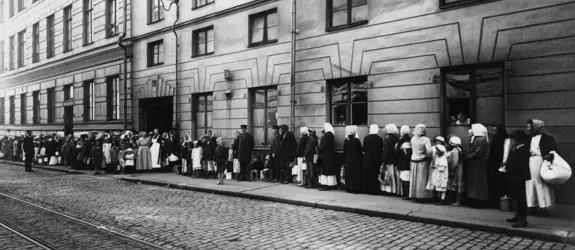 Kvinnor i en lång kö för livsmedelskort på Katarinagatan, utanför Helsingfors stads livsmedelsnämnds kortkansli vid stadshuset.