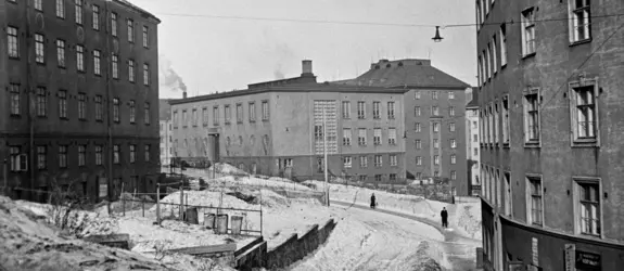 Flervåningshus och människor som går på en snöig gata.