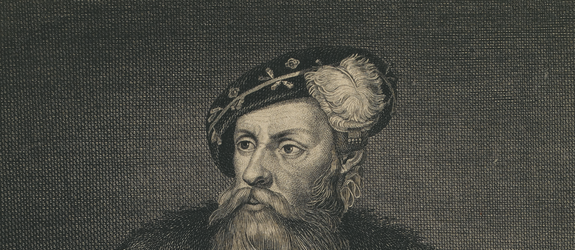 A picture of a middle aged man with a long beard and mustache. Large crucifix hangs from his neck. Dressed in a long coat and hat. Holding a telescope in his left hand.