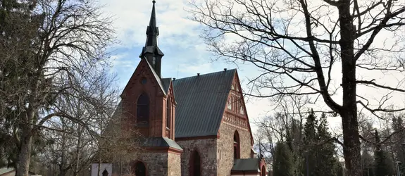 Kuva keskiaikaisesta kirkosta lumilaikkujen ympäröimänä