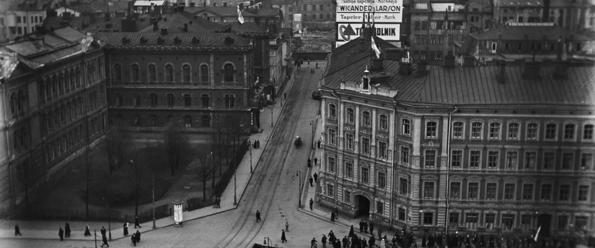 Näkymä Rautatieaseman tornista Hakasalmenkadun (= Keskuskatu) ja Kaivokadun risteykseen. Vasemmalla Ateneum, Hakasalmenkatu 1 (= Keskuskatu 9) ja Hakasalmenkatu 3 (= Keskuskatu 7), Vapaapalokunnan (VPK:n) talo. Oikealla Hakasalmenkatu 2 (= Keskuskatu 8). Arkkitehdit Theodor Höijer ja F.A. Sjöström. Skohan talona tunnettu rakennus valmistui 1870-luvulla ja purettiin 1965. Taustalla Hakasalmenkatua jatketaan kohti Esplanadia.