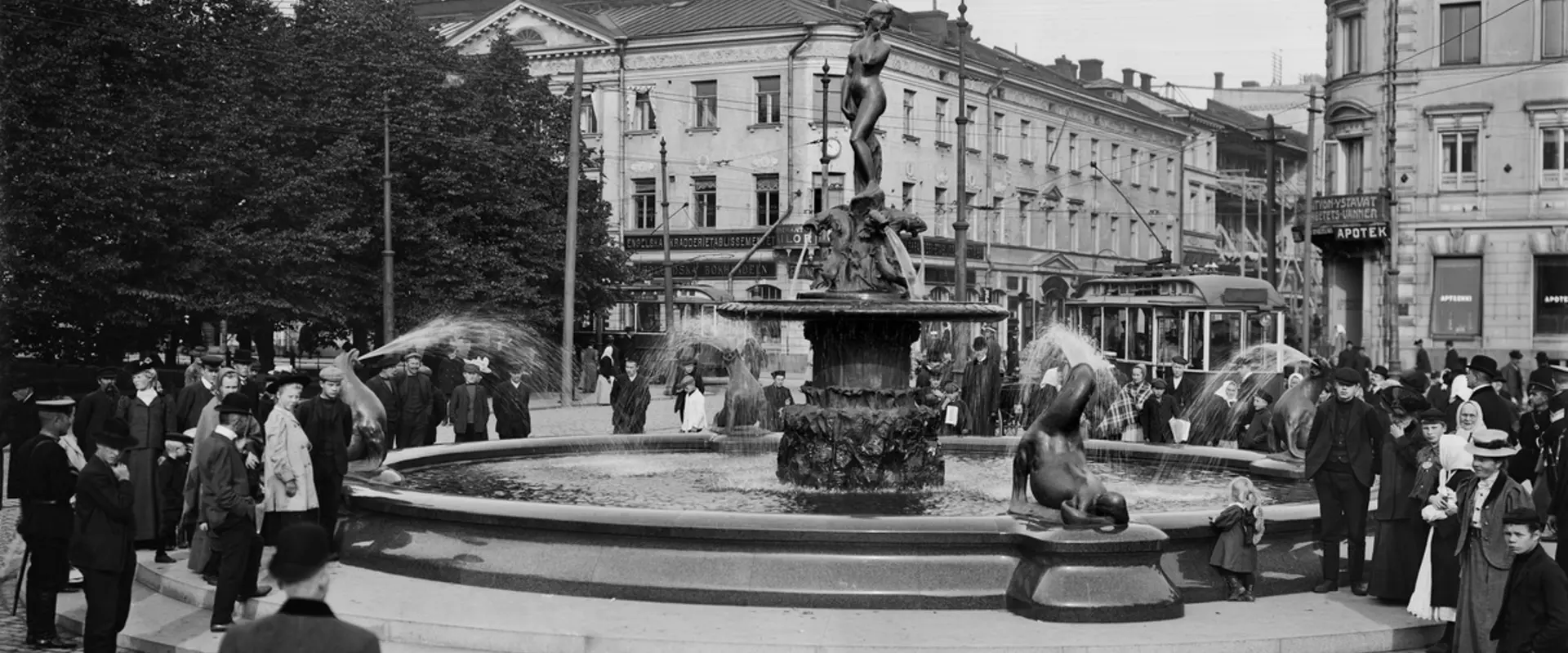 Havis Amanda -suihkukaivo Kauppatorilla paljastustilaisuuden jälkeen. Taustalla Pohjoinen Esplanaadikatu (Pohjoisesplanadi) 19 - Unioninkatu 28.