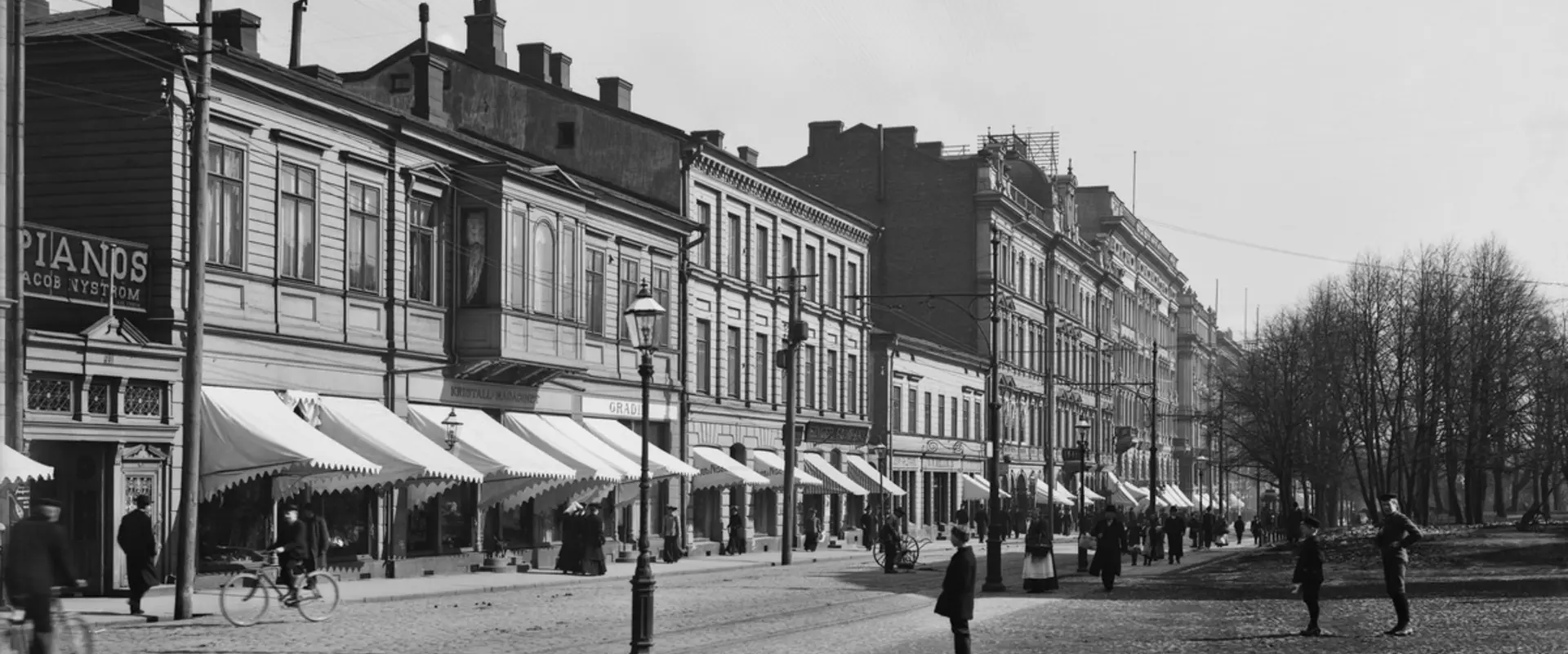 Norra Esplanaden 41, 39, 37, 35. Två- och trevåningsbyggnader, fotgängare, kärror och en gaslykta. 