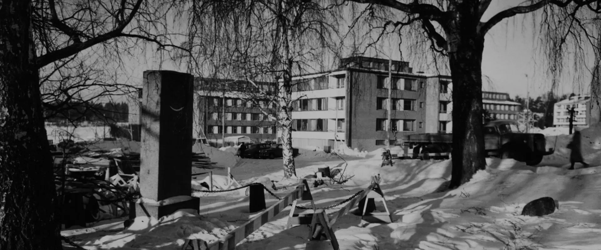 Suorakulmainen kivipaasi lumisessa maisemassa.