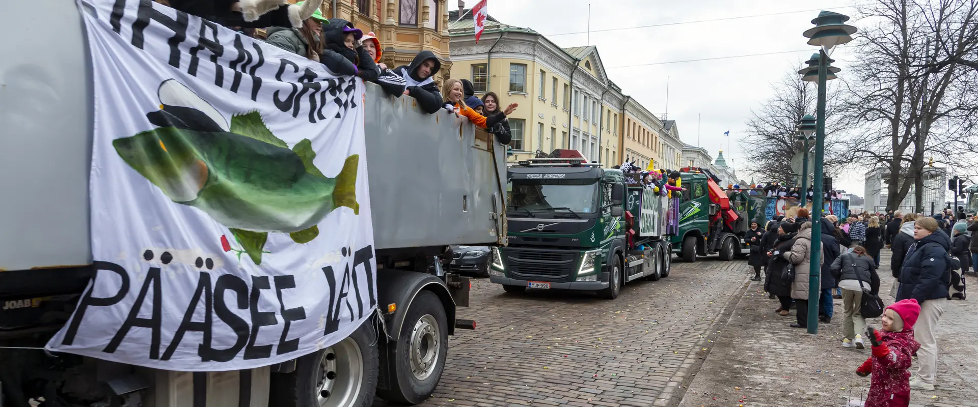 Abiturienter åker med lastbil längs Södra Esplanaden. Människor har samlats för att titta på dem.