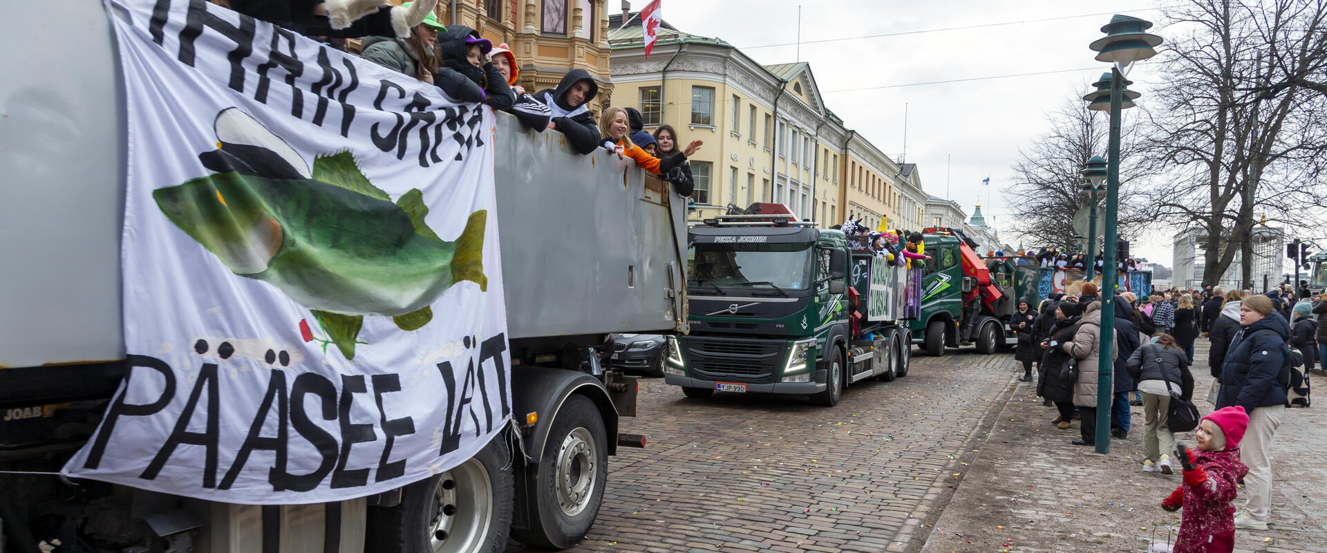 Abiturienter åker med lastbil längs Södra Esplanaden. Människor har samlats för att titta på dem.