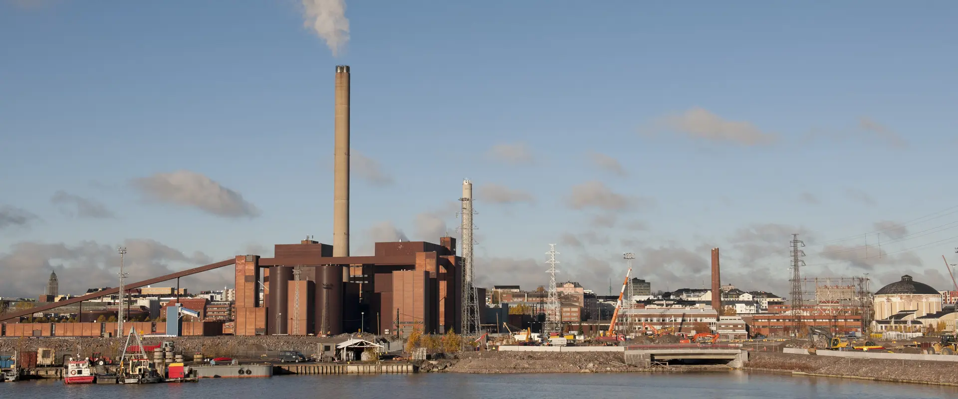 Maisemakuva Hanasaaren voimalaitoksesta ja Suvilahden kaasukelloista.