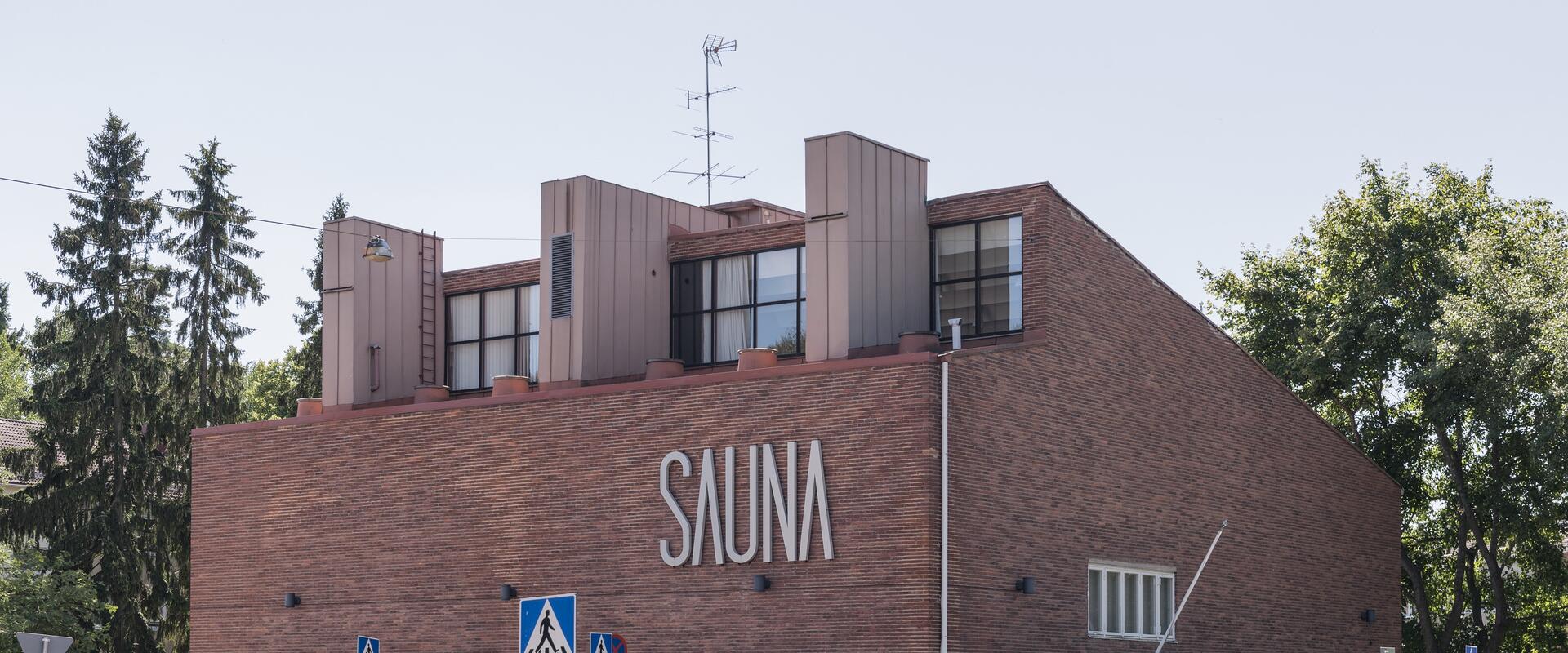 Tiiliverhoiltu rakennus, jossa suurin suuraakkosin teksti Sauna.