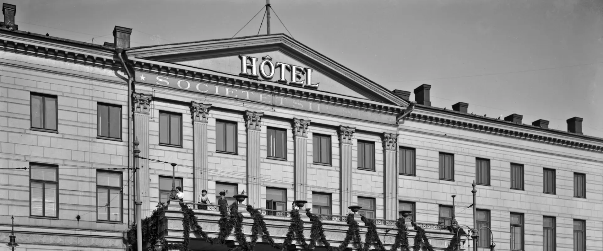 A photograph of the current Helsinki City Hall with the text “Hotel Societetshuset” on its wall.