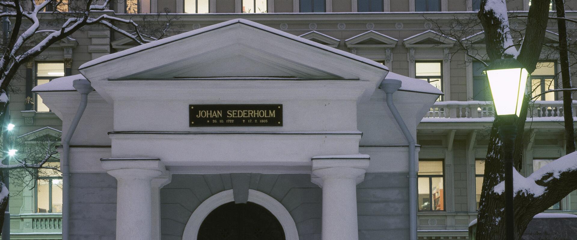 Kuva uusklassisesti koristeellisesta pienestä kivisestä rakennuksesta. Oven yläpuolella lukee Johan Sederholm.