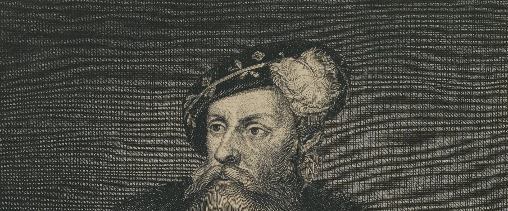 A picture of a middle aged man with a long beard and mustache. Large crucifix hangs from his neck. Dressed in a long coat and hat. Holding a telescope in his left hand.