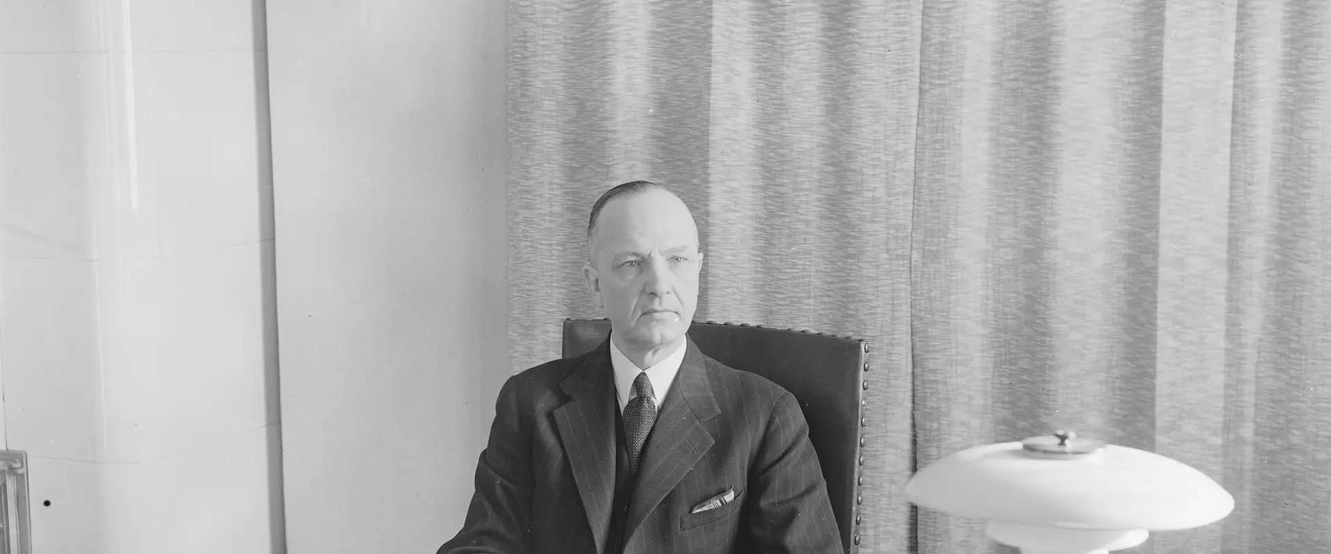 Eero Rydman sitter bakom sitt skrivbord och tittar mot kameran.