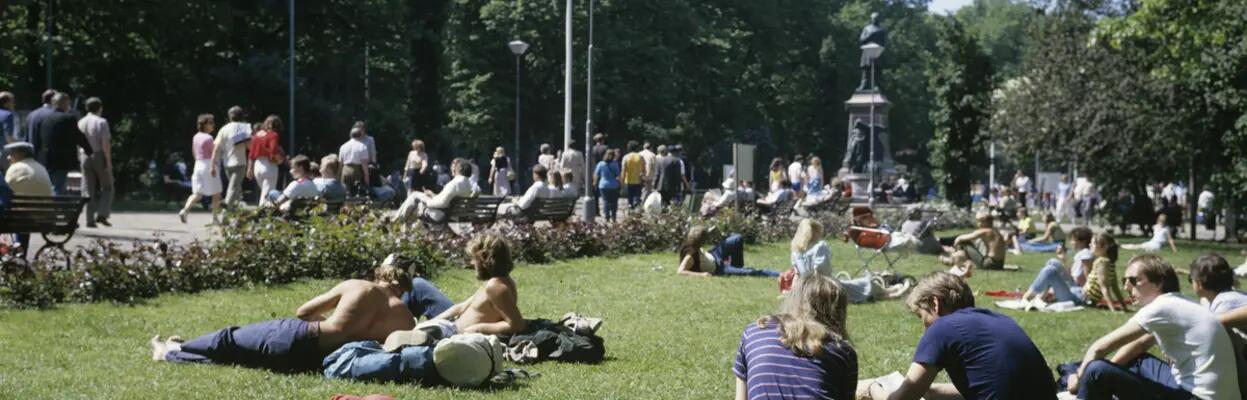 Nuoria paistattelemassa päivää Esplanadin puiston nurmikolla