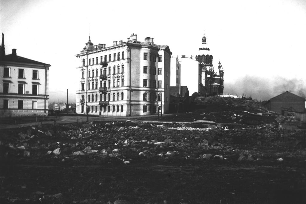  The house built by merchant Nikolai Wavulin (the lower building on the left) at Satamakatu 9 was Katajanokka's first residential building built by a private person and was completed in 1869. Wavulin sold his house to Aurora Karamzin, who founded the Deaconess Foundation. The foundation operated there for 23 years before moving to its current premises in Alppila. Coffee pots were produced there from 1909 to 1937 and it functioned as a coffee storehouse from 1937 to 1979. The house in the middle of the picture is called Enen (Kataja, juniper). The house was designed by Professor Gustaf Nyström and it was completed in 1897.

 Photo: Helsinki City Museum