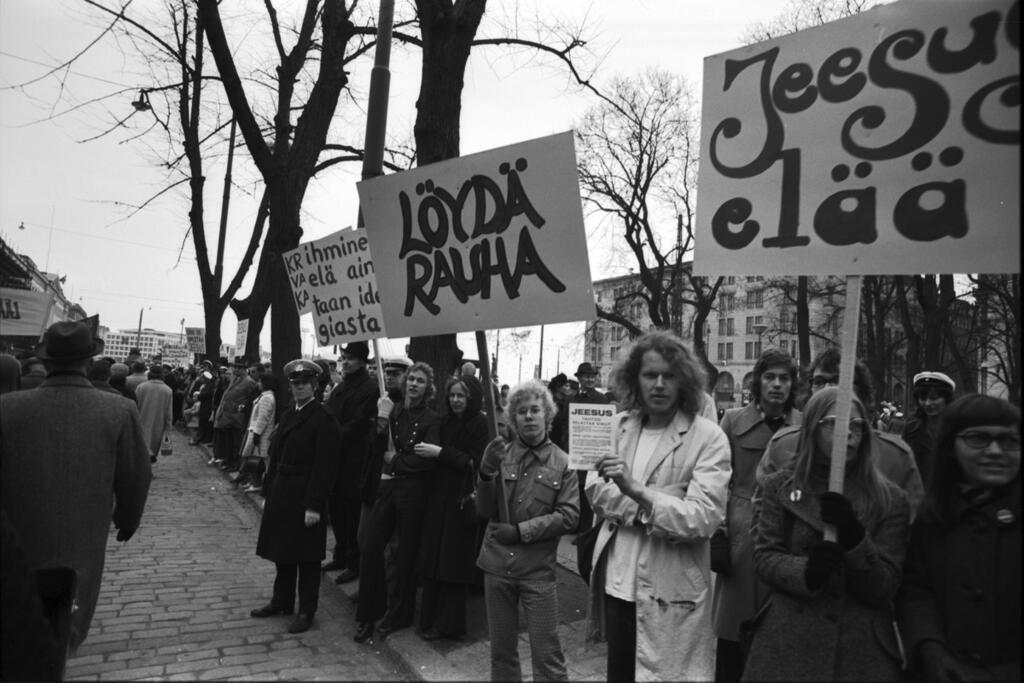 Deltagare i ett Jesuståg med sina plakat längs rutten för arbetarnas förstamajtåg vid Kapellesplanaden 1.5.1972. Foto: Helsingfors stadsmuseum / Simo Rista
