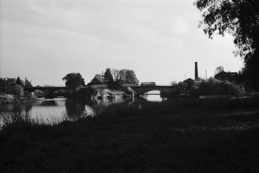 En spegelblank Vanda å med bågbro. I mitten Kungsgårdsholmen.  Foto: Helsingfors stadsmuseum / Simo Rista