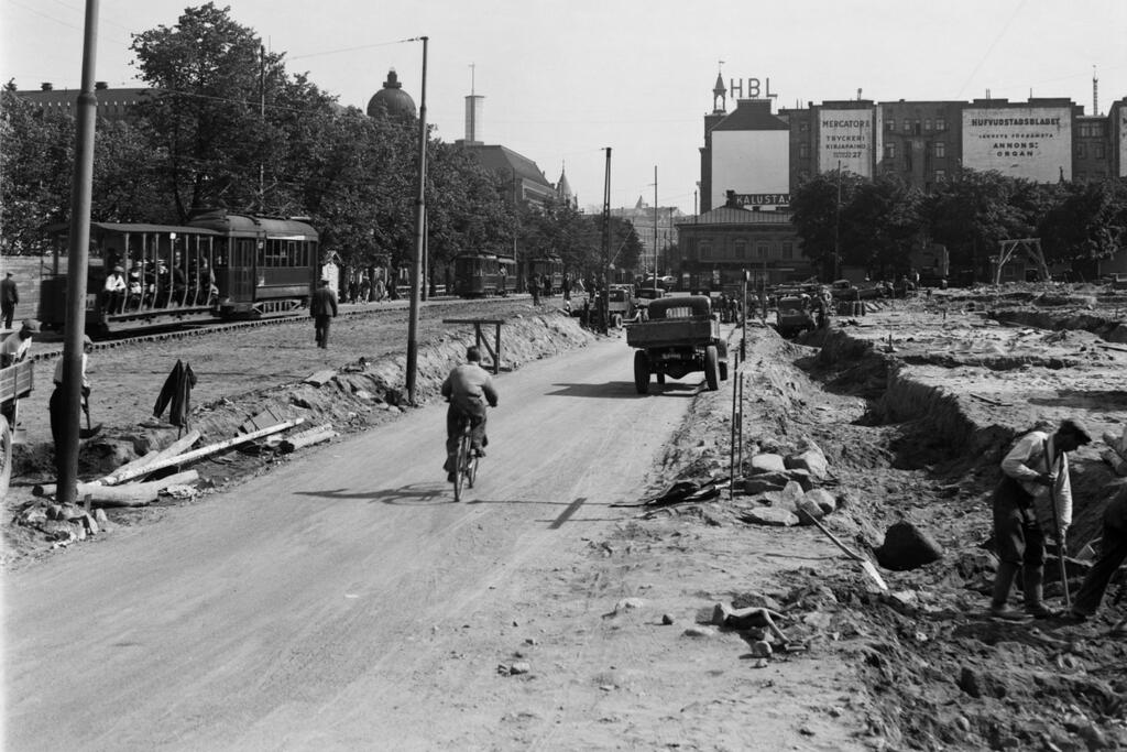 Vägarbeten på Henriksgatan, nuvarande Mannerheimvägen, år 1935. Till höger börjar byggandet av Glaspalatset. Foto: Helsingfors stadsmuseum / Foto Roos