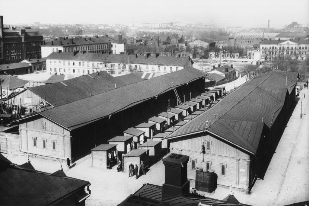 Narinkkatori oli nykyisen hotelli Scandicin alueella, jossa vuosina 1876–1929 juutalaiset ja venäläiset kauppiaat myivät vaatteita ja tekstiilejä. Narikkatori oli siirretty Kamppiin nykyisen Suomen Pankin paikalta, kun pankkirakennusta alettiin suunnitella 1870-luvulla.   Kuvaaja: Helsingin kaupunginmuseo / R. Roos