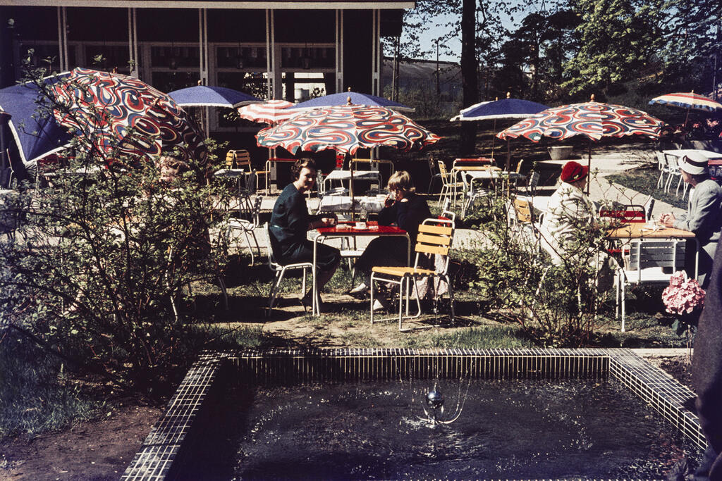 Helsingin Sanomat skrev den 20 juli 1957 om ett nytt utecafé som har öppnats vid Tölöviken bakom sockerfabriken. "En rolig nyhet är den öppna eldstaden på gården, där kafégästerna kan grilla korv." Foto: Helsingfors stadsmuseum / Risto Reinikainen