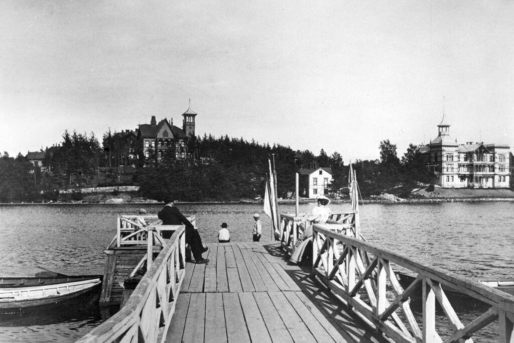 Båtbrygga vid Tölövikens västra strand. På nuvarande Hesperiaparkens plats fanns ett villaområde med samma namn, och en uteservering.  Foto: Helsingfors stadsmuseum