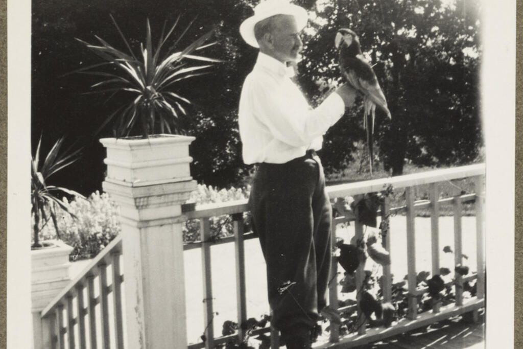 Konsul, verkställande direktör Leonard Wasenius (1866–1938) hade hämtat med sig en papegoja från Sydamerika. Här står han på terrassen till sin villa Anneberg cirka år 1910. Villan är den äldsta i Helsingfors och inhyser nuförtiden ett kafé och ägs av Nyttoväxtföreningen rf. Foto: Museiverket