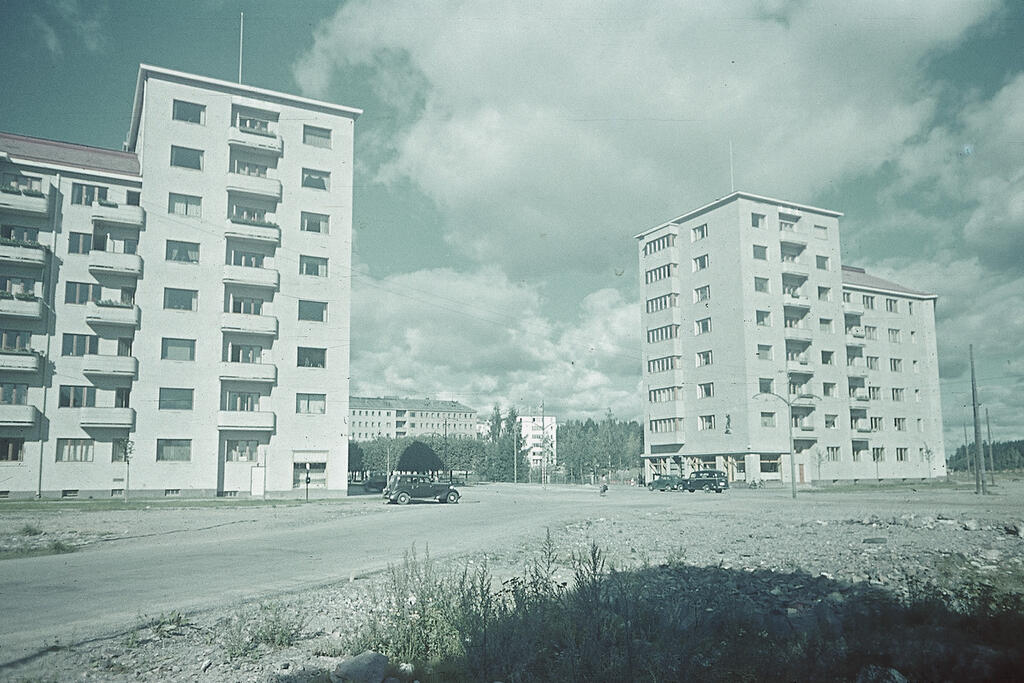 Rakentaminen oli vilkasta 1930-luvun jälkipuoliskon nousukaudella, joka loppui talvisotaan. Tämä harvinainen värikuva on vuodelta 1939. Vasemmalla oleva rakennus on Munkkiniemen puistotie 2, oikealla Munkkiniemen puistotie 1. Kuvaaja: Museovirasto / Aarne Pietinen Oy