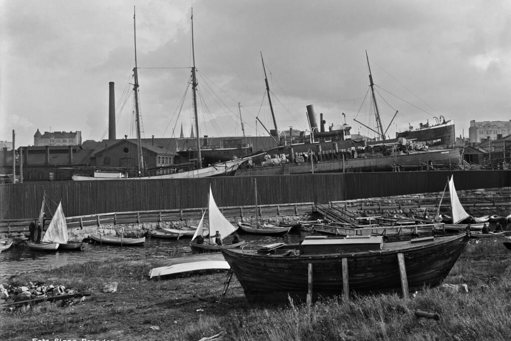 Bakom stängslet syns Sandvikens varv, i förgrunden Munkholmen. Foto: Helsingfors stadsmuseum / Signe Brander