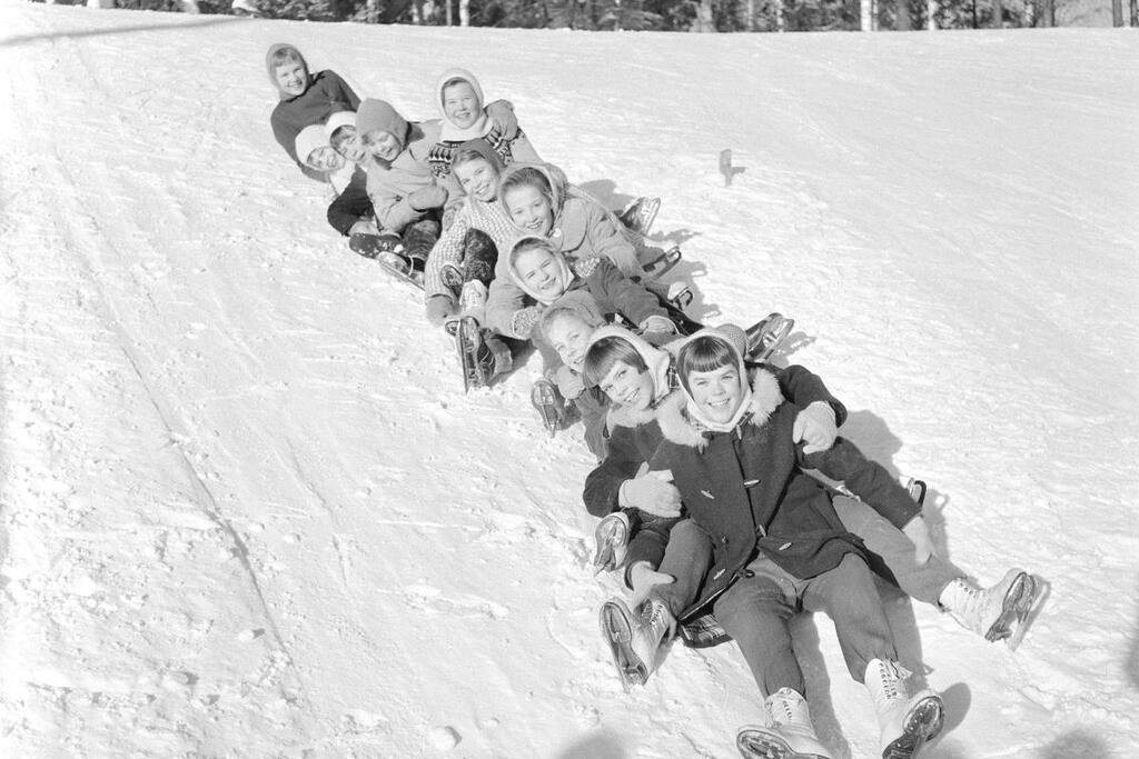 Tässä lasketaan mäkeä oikein porukalla laskiaisena 1959, todennäköisesti luistelun päätteeksi. Kuvaaja: Museovirasto / István Rácz