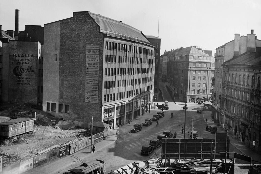 Uuden kadun rakentaminen vaati tietysti rakennusten purkamista ja korvaamista uusilla. 1920-luvulla rakennetut punatiilitalot antoivat kadulle yhtenäisen ilmeen. Kaisaniemenkatu 7 ja 3 sekä Vuorikatu 14 ja 16. Tyhjät tontit etualalla ovat Kaisaniemenkatu 6, Vuorikatu 15 ja Kaisaniemenkatu 9. Kuvaaja: Helsingin kaupunginmuseo / Anton Rönnberg