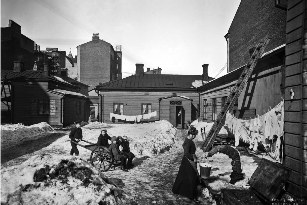 Työläisten asuintaloissa yhteinen vesihana sijaitsi tavallisesti sisäpihalla. Pieni Roobertinkatu 4– 6:n sisäpihaa vuonna 1907. Kuvaaja: Helsingin kaupunginmuseo / Signe Brander