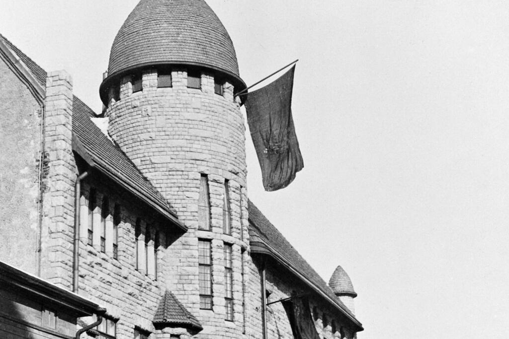 Till en början väckte revolutionen iver i alla befolkningsskikt. Lejonfanan (Finlands gamla flagga) hissad i tornet på Tekniska Högskolans studentkårs hus vid Andraegatan (numera Lönnrotsgatan) den 20 mars 1917. ”Finlands vita flagg med blåa korset på” ersatte den rödgula lejonfanan först i maj 1918. Foto: Helsingfors stadsmuseum / Okänd fotograf