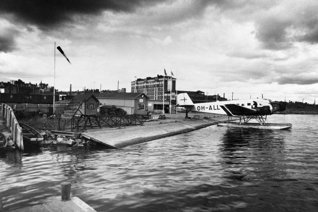 Hydroplan vid Skatuddens sjöflygplats. Bakom flygmaskinen skymtar flygplatsens anspråkslösa byggnader