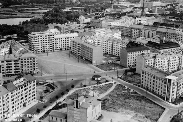 Flygbild från Tölö torgs område. På bilden syns obebyggda tomter och i förgrunden Tölö kyrka.