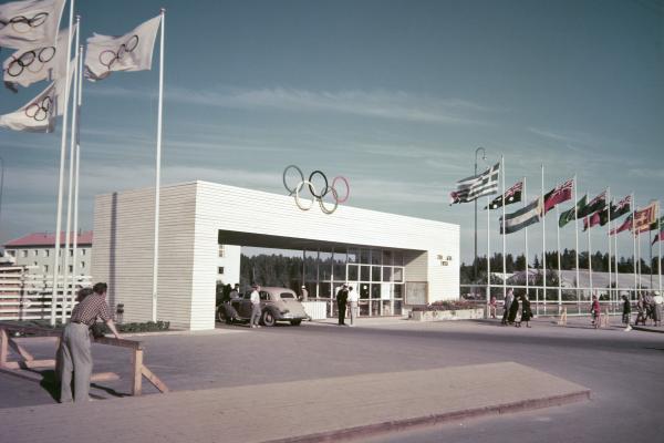 Käpylään rakennetun Olympialaisten kisakylän portti Koskelantiellä. Porttia ympäröivät osallistujamaiden liput.