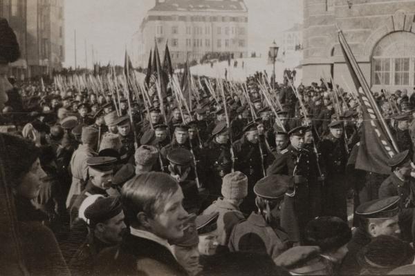 Venäläiset sotilaat juhlivat kulkueessa Maaliskuun vallankumousta vuonna 1917. Kulkue on täynnä univormupukuisia miehiä, jotka kantavat lippuja.