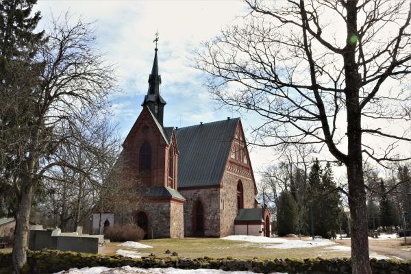 Fotografi av medeltida stenkyrka omgiven av smältande snö