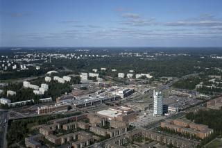 Flygbild över stadsdelen Östra centrum från söder mot norr. I förgrunden Österleden och nya byggnader, i bakgrunden skog och äldre höghus.