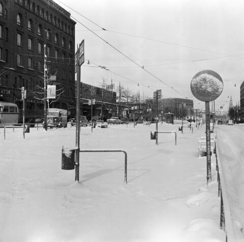 Auraamattomat raitiotiekiskot Mannerheimintiellä Ylioppilastalon edustalla. Takana: Mannerheimintie 18. Forum (Mannerheimintie 20. - Simonkatu 2.). Eduskuntatalo (Mannerheimintie 30).