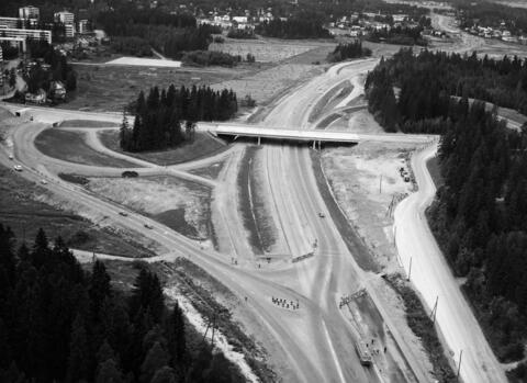 Ilmakuvassa Tuusulantien ja Käskynhaltijantien liittymä. Autoliikennettä on vähän, ympärillä on metsää ja peltoa, taustalla uusia kerrostaloryppäitä.