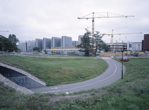 Lepakkoluola ja sen ympäristöä pohjoispuolella, etualalla Länsiväylän alikulkutunneli, taustalla Ruoholahden toimistotaloja ja rakennustyömaata nostokurkineen, Ruoholahti.