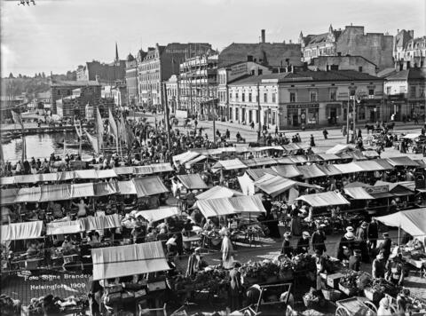 Kauppatori on täynnä myyntikojuja ja ihmisiä. 