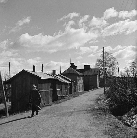 Matalia puutaloja hiekkatien varressa.