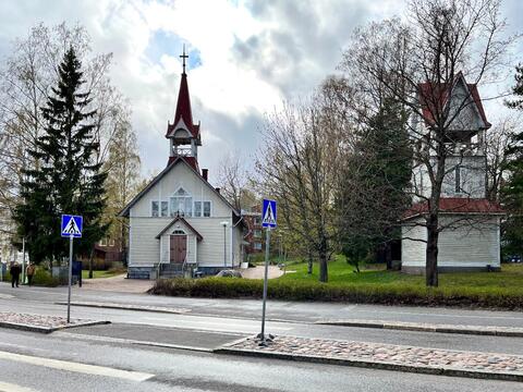 Sirorakenteinen valkoinen puukirkko, jossa on harjakaton jatkeena korkea torni. Vieressä on erillinen kellotapuli.