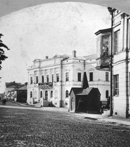 Vanha ylioppilastalo, Läntinen Heikinkatu (= Mannerheimintie) 3. Piirtänyt Hampus Dalström, 1870. Etualalla kaivo.