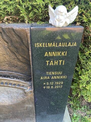 Mustassa graniittipaadessa on kultaisin kirjaimin teksti: ISKELMÄLAULAJA ANNIKKI TÄHTI TIENSUU AIRA ANNIKKI s. 5.12.1929, k. 19.6.2017