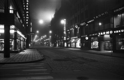 Aleksanterinkatu. Näkymä illalla autiolta ja sumuiselta Aleksanterinkadulta Kluuvikadun kulmasta länteen.