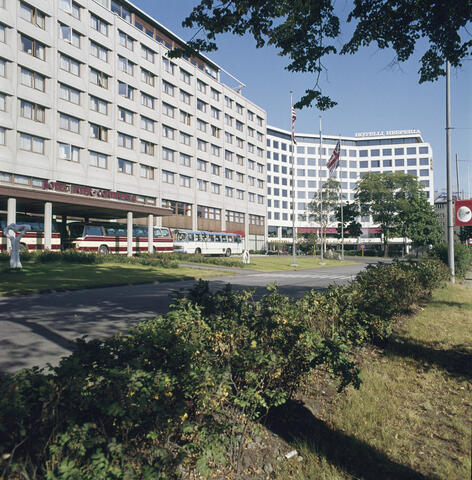 Värikuvassa kaksi vierekkäistä vaaleasävyistä noin 9-kerroksista hotellirakennusta.